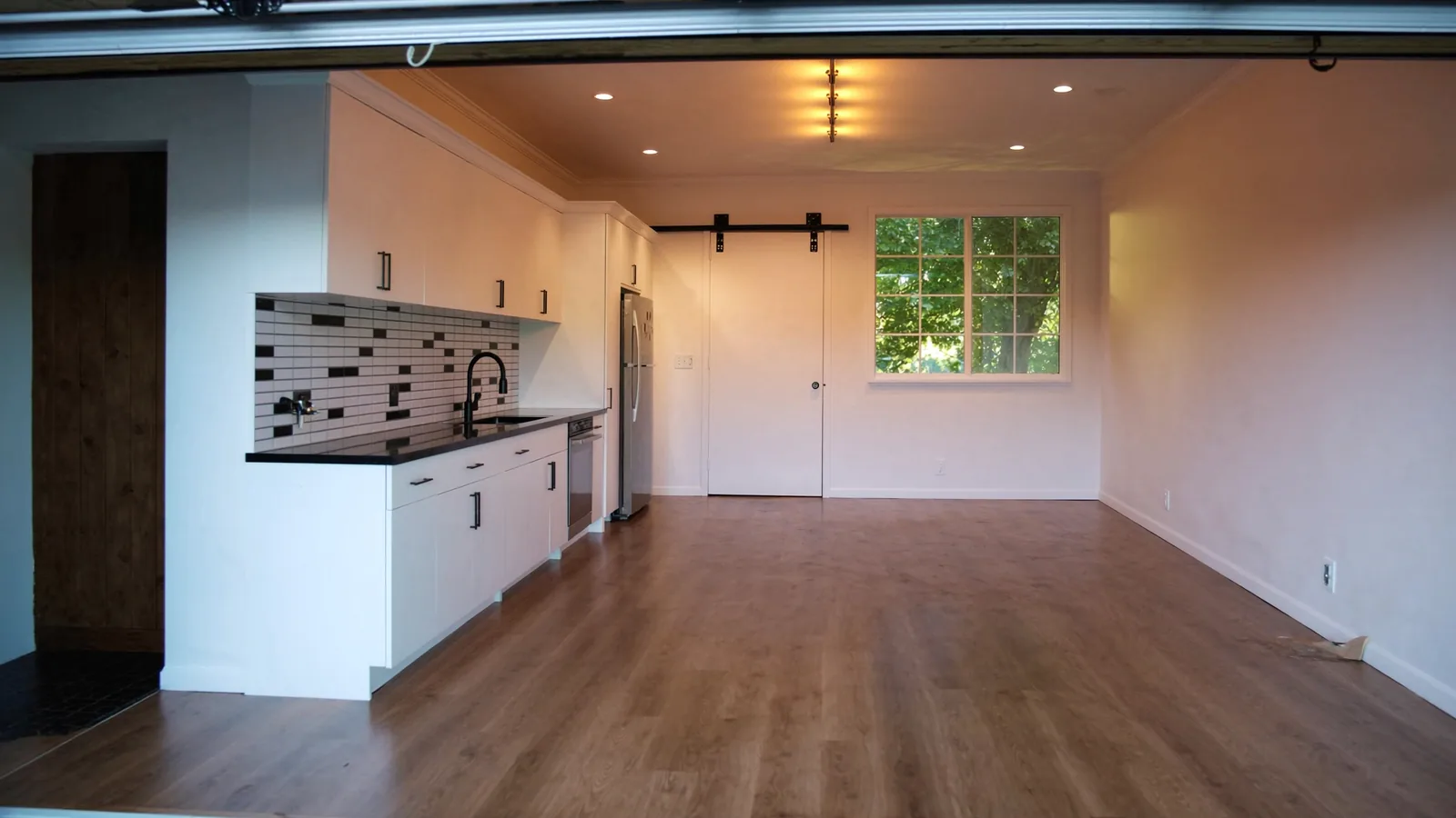 The same garage after conversion to finished office — drywall, insulation, ductless mini-split, built-in shelving, dedicated electrical